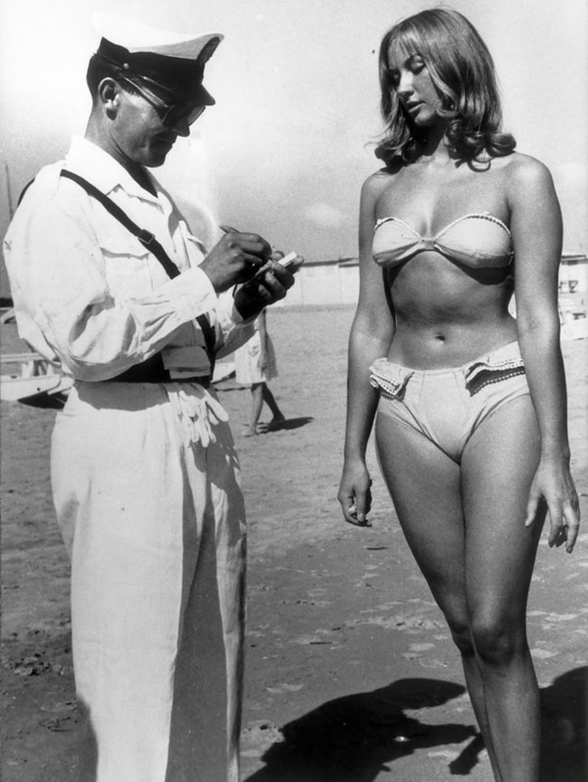 A police officer issuing a woman a ticket for wearing a bikini on an Italian beach, 1957.jpg